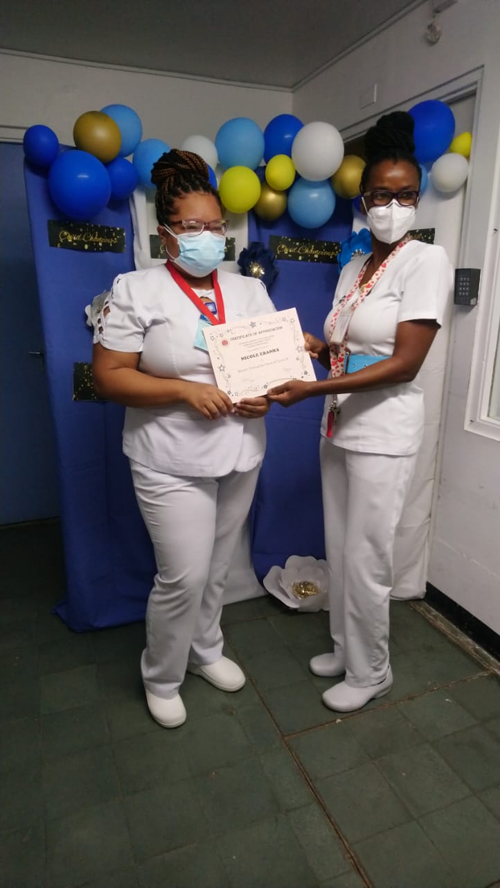 Sister Jullet Harris presents Nurse Nicole Ebanks with a certificate.